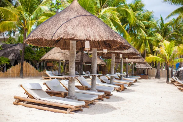 Парадоксальный вид на красивый пустой песчаный пляж с зонтиком и пляжным шезлонгом — стоковое фото