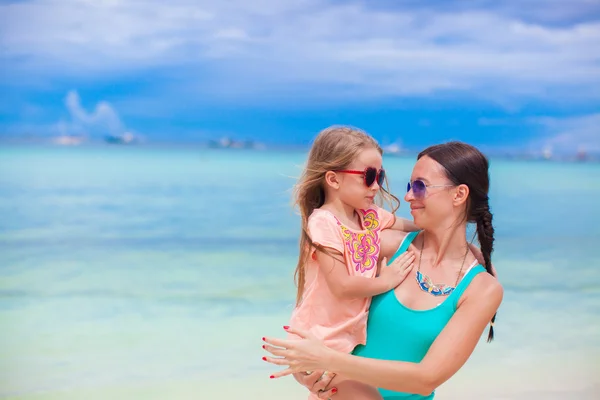 Nahaufnahme kleines Mädchen und ihre junge Mutter schauen einander am Strand an — Stockfoto