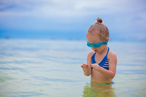 Meisje met glazen voor zwemmen zwemt en duiken in de zee — Stockfoto