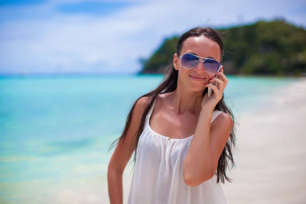 Giovane bella donna in spiaggia a parlare sul suo telefono — Foto Stock