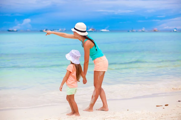 Bakifrån av mamma pekar på lilla dotter i havet — Stockfoto