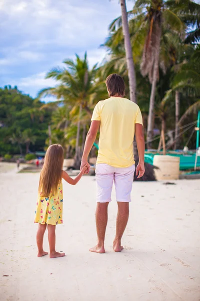 Вид сзади отца с восхитительной дочерью, гуляющей на пляжном отдыхе — стоковое фото