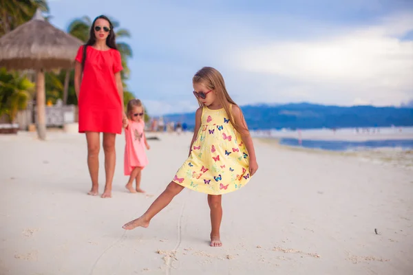 Beautiful mother and two her kids at exotic beach on sunset — Stock Photo, Image