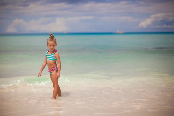 Adorable little girl walking in the water on tropical beach vacation — Stock Photo, Image