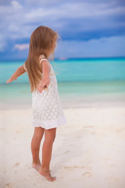 Schönes kleines Mädchen breitet ihre Arme an einem exotischen Strand aus — Stockfoto