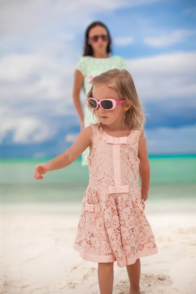 Närbild lilla flickan och hennes unga mor på den vita stranden — Stockfoto