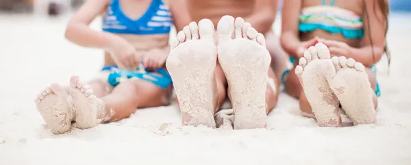 Close-up dos pés da mãe e duas filhas na praia de areia branca — Fotografia de Stock