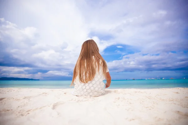 Visão traseira de pouco bonito menina siiting na praia — Fotografia de Stock