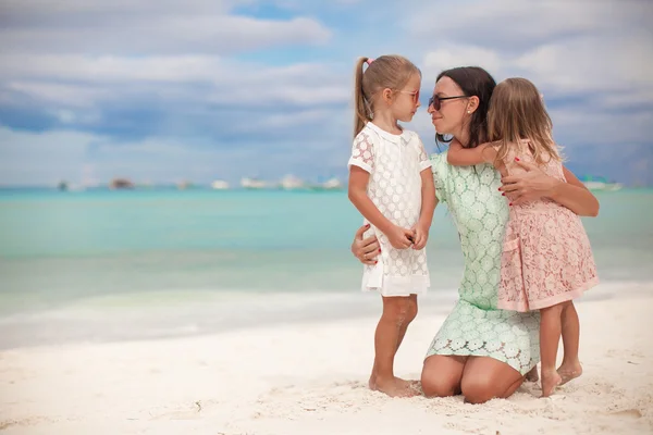 Fashion mother and two her adorable daughters at exotic beach on sunny day — Stock Photo, Image