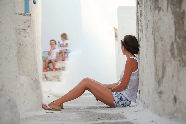 Young mother background her dear daughters in a Greek village on the Cyclades Islands — Stock Photo, Image