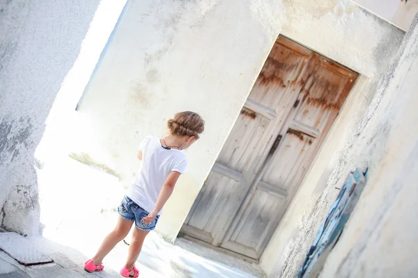 Sevimli kız yalnız emporio köyün dar sokaklarında yürüyüş Adası santorini, Yunanistan — Stok fotoğraf