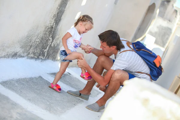 Junger Vater bemitleidet seine kleine Tochter, die sich auf griechischer Straße am Bein verletzt — Stockfoto