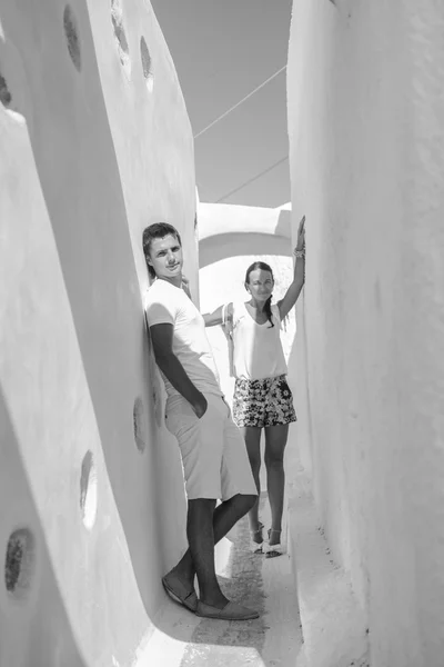 Pareja joven caminando en un antiguo pueblo griego en la isla de Santorini, Grecia — Foto de Stock