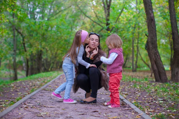 Jovem mãe com suas filhas se divertindo no Outono parque — Fotografia de Stock
