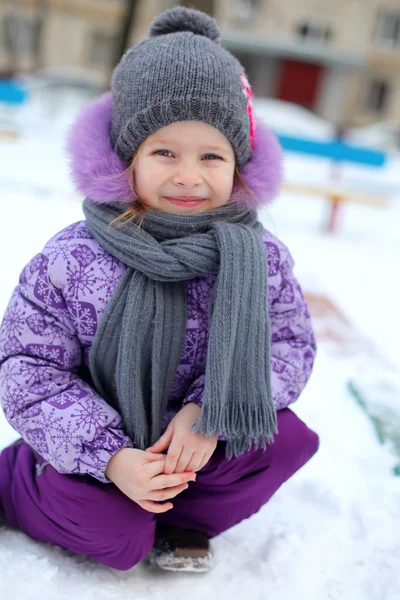 Primo piano della bambina carina felice che si diverte sulla neve in una giornata invernale soleggiata — Foto Stock