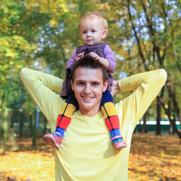 Junger Vater spaziert mit seiner kleinen süßen Tochter im Herbstpark im Freien — Stockfoto