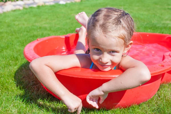 Portrait of relaxing charming little girl enjoying her vacation in small pool — Stock Photo, Image