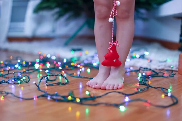 Pequeño árbol rojo en las manos de la encantadora chica linda en el fondo de luces brillantes —  Fotos de Stock