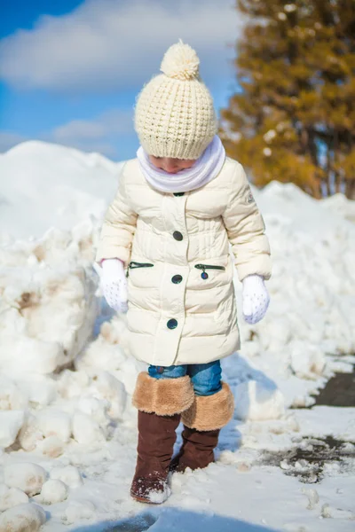 Primo piano della bambina carina felice che si diverte sulla neve in una giornata invernale soleggiata — Foto Stock