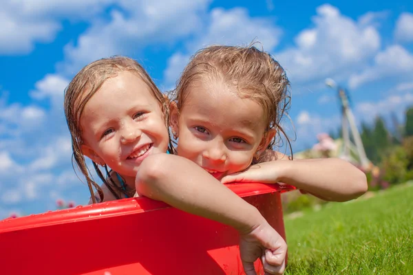 Két aranyos kis lány boldog szórakozás a kis medence, kültéri udvaron — Stock Fotó