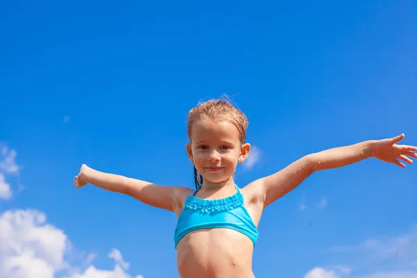 Beautiful little girl spread her arms background of the blue sky — Stock Photo, Image