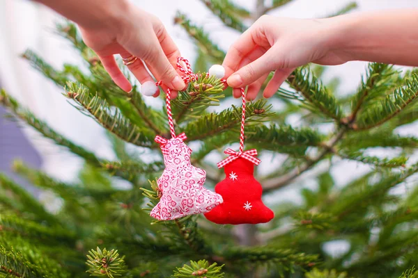 Gros plan d'une main décorant les ornements traditionnels des sapins de Noël — Photo