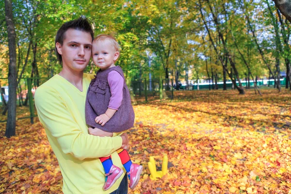 Jovem pai caminhando com sua filhinha fofa caminhada no parque de outono ao ar livre — Fotografia de Stock