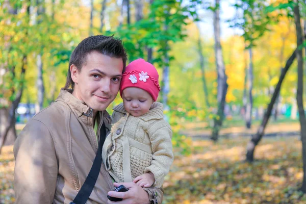 Junger Vater spaziert mit seiner kleinen süßen Tochter im Herbstpark im Freien — Stockfoto