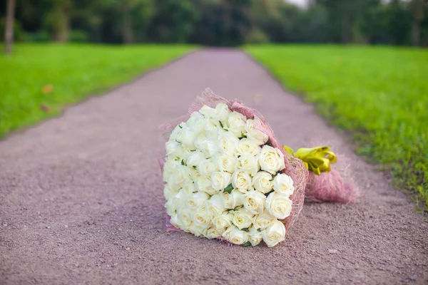 Incredibly beautiful large bouquet of white roses on a sandy path in the garden — Stock Photo, Image