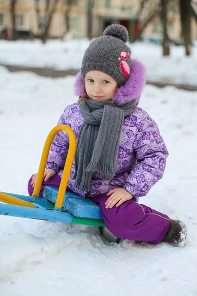 Porträtt av lilla söta glad tjej att ha kul i snön på en solig vinterdag — Stockfoto