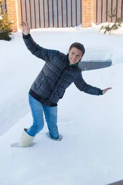 Giovane uomo in stivali invernali è caduto in una neve bianca profonda — Foto Stock