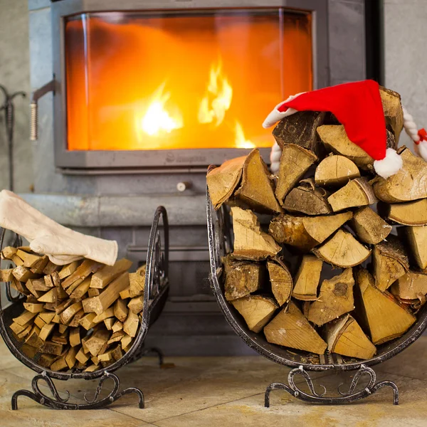 Legna da ardere con cappello di Babbo Natale in casa vicino a un camino — Foto Stock