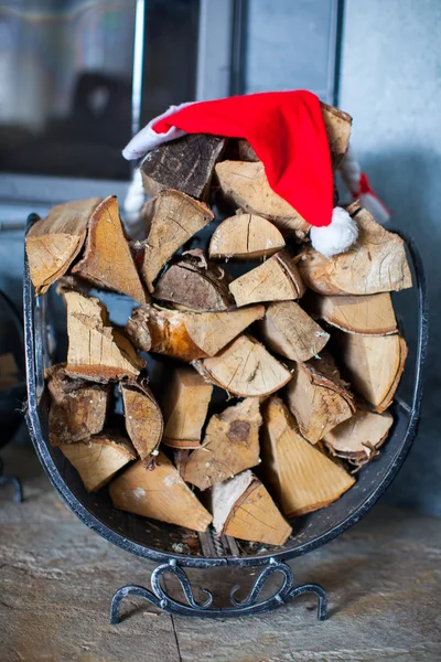 Noel Baba şapkası evin yakınındaki bir şömine odunları — Stok fotoğraf