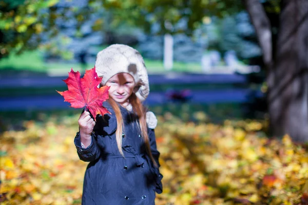 Närbild rött lönnlöv i händerna på liten flicka vacker höst dag — Stockfoto