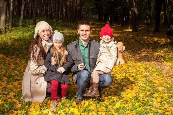 Adorabile famiglia di quattro persone che si gode una splendida giornata di sole autunnale nel parco — Foto Stock