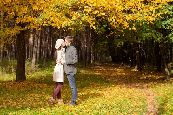 Pareja joven besándose en el parque de otoño en un día soleado de otoño — Foto de Stock