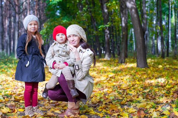 Giovane madre con la sua meravigliosa bella figlia passeggiata nel parco autunnale in una giornata di sole caldo — Foto Stock