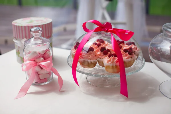 Krug mit bunten Pariser Macarons und leckeren Kuchen auf dem Hochzeitstisch — Stockfoto