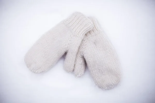 Soft, warm, knitted mittens on the white snow — Stock Photo, Image