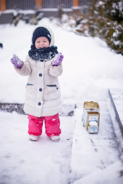 Piccola ragazza divertente e allegra divertirsi in cortile in inverno giornata di sole — Foto Stock