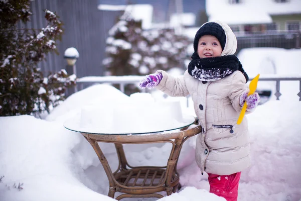 Little funny girl having fun and playing in the yard at winter sunny day — Stock Photo, Image