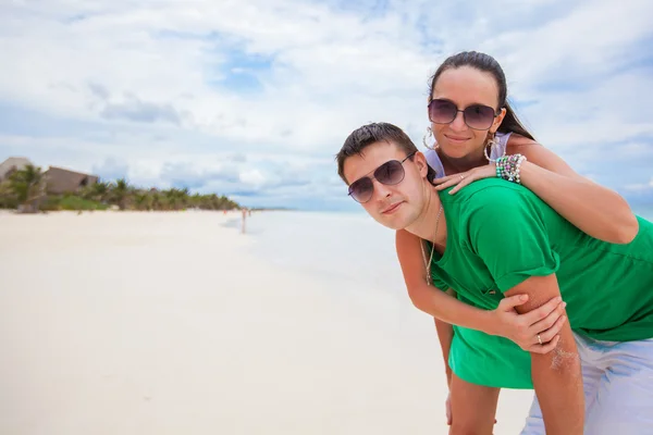 Feliz joven pareja se divierten en la playa exótica mirando a la cámara — Foto de Stock