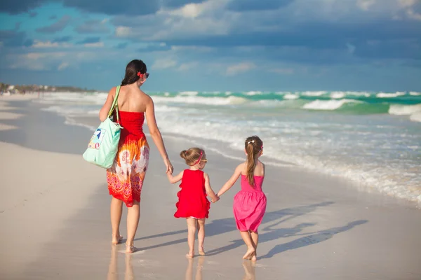 Mladá matka a dva její módní děti na exotické pláži slunečného dne — Stock fotografie