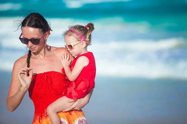 Jovem mãe e sua filhinha andando na praia tropical — Fotografia de Stock