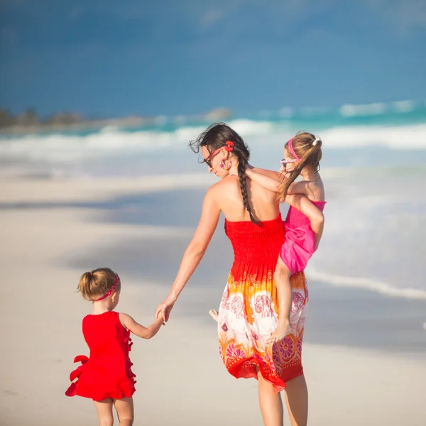 Mother and two her cute daughters walking at exotic beach on sunny day — Stock Photo, Image