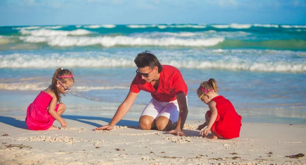 Joven padre y sus adorables hijas jugando en la playa — Foto de Stock
