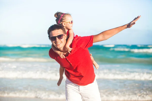 Young father and his adorable little daughter flying like a bird at tropical beach — Stock Photo, Image