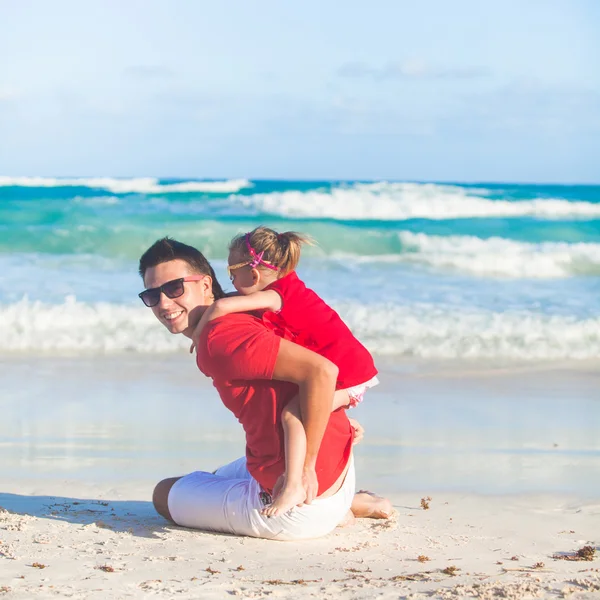 Little cute girl and her young father having fun at white beach — Stock Photo, Image