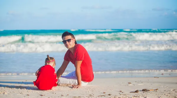 Jovem pai e sua adorável filhinha brincando na praia — Fotografia de Stock