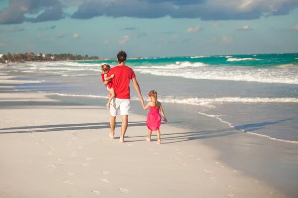 Οπίσθια όψη της μικρά πατέρας με τις κόρες του χαριτωμένο περπάτημα κατά μήκος της θάλασσας — Φωτογραφία Αρχείου